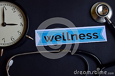 Wellness on the print paper with Healthcare Concept Inspiration. alarm clock, Black stethoscope. Stock Photo