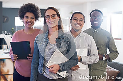 Were all included in the reach for success. Portrait of a group of confident young businesspeople working in a modern Stock Photo