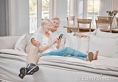 Were definitely two of a kind. a elderly couple using a cellphone at home. Stock Photo