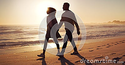 Were going where love leads us. Full length shot of an affectionate young couple taking a stroll on the beach at sunset. Stock Photo