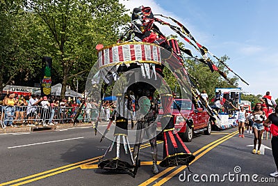 West Indian Labor Day Parade with a man in a beautiful costume, cars and large crowds Editorial Stock Photo