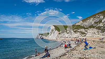 Sunbathers enjoying the warm sunshine at Durdle Door beach of Jurassic Coast, West Lulworth, United Kingdom Editorial Stock Photo