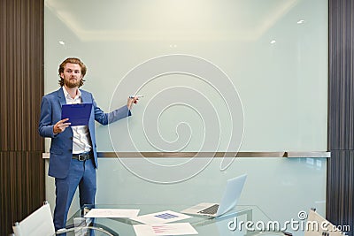 Western businessman presenting a project on blank glass board in Stock Photo