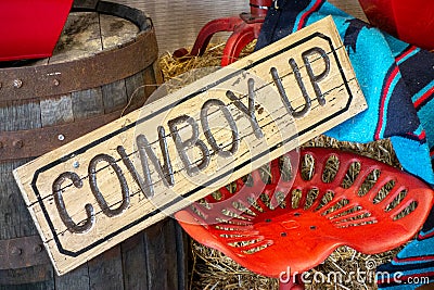 Western decor with Cowboy up sign and painted red vintage tractor seat Stock Photo