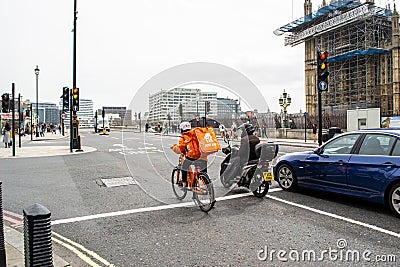 WESTMINSTER, LONDON, ENGLAND- 31 March 2021: Just Eat delivery cyclist Editorial Stock Photo