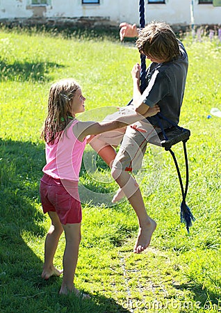 Wet boy and girl on a swing Stock Photo