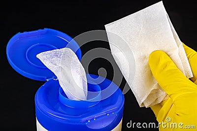 A wet cleaning cloth in a plastic container. Handkerchief with a yellow glove Stock Photo