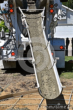 Wet concrete coming dow a chute of a emend truck Stock Photo