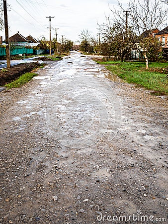 wet dirty gravel road in village after rain Stock Photo