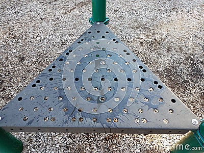 Wet metal triangle playground surface with holes and water Stock Photo