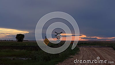 A closed dirt road over a railway crossing with a sunset Stock Photo