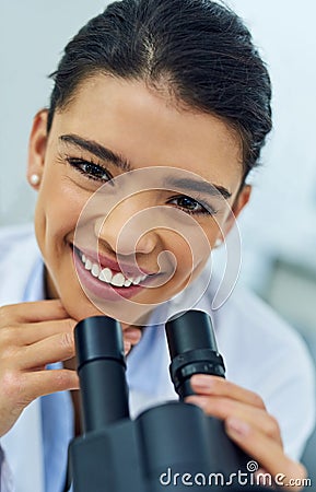 Weve just reached another medical breakthrough. Portrait of a young scientist using a microscope in a lab. Stock Photo
