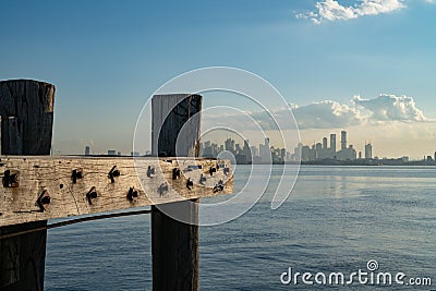 Wharf piles and beams at end of dock with CBD skyline of Melbourne in background across harbour Stock Photo