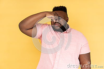 Man pinching nose, stop breathing bad odor, disgusted by smell of farting, expressing repulsion. Stock Photo