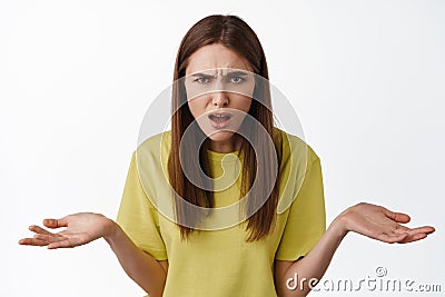 What big deal. Frustrated and confused woman shrugging, staring at camera annoyed, cant understand smth strange, wtf Stock Photo