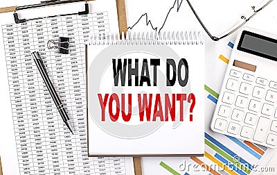 WHAT DO YOU WANT text on notebook with chart, calculator and pen Stock Photo