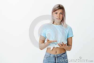 What hel he dumped me via message. Portrait of frustrated shocked cute woman in blue cropped top, holding smartphone and Stock Photo