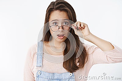 What hell going on. Portrait of shocked speechless and questioned female brunette taking off glasses dropping jaw and Stock Photo