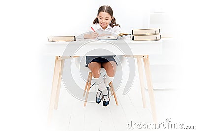 What should be height of study table. Schoolgirl doing homework at table. Adorable pupil little girl studying at table Stock Photo