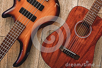 What to choose Top view on two cool musical instruments: acoustic and electric guitars are lying on the wooden floor in Stock Photo