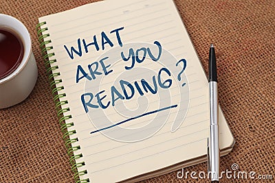 What are you reading, text words typography written on paper against wooden background, life and business motivational Stock Photo