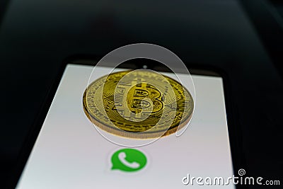 WhatsApp application on smartphone and bitcoin cryptocurency. WhatsApp launches cryptocurrency payments Editorial Stock Photo