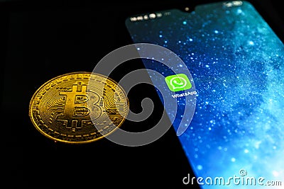 WhatsApp application on smartphone and bitcoin cryptocurency. WhatsApp launches cryptocurrency payments Editorial Stock Photo