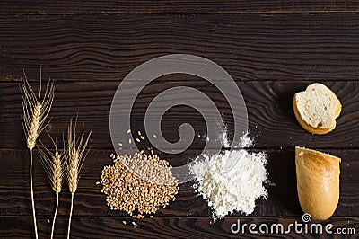 Wheat ears, grains, flour and sliced bread on a dark wooden table Stock Photo