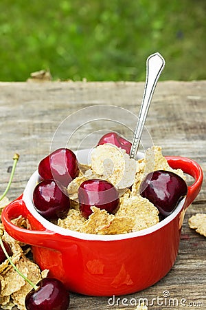 Wheat flakes with cherry pieces in a ceramic pot Stock Photo