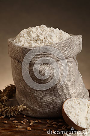 Wheat flour, grains and spikes on wooden table, closeup Stock Photo