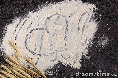 Wheat flour is scattered on a dark background. The ingredient. Bakery products. A heart is drawn on the flour Stock Photo