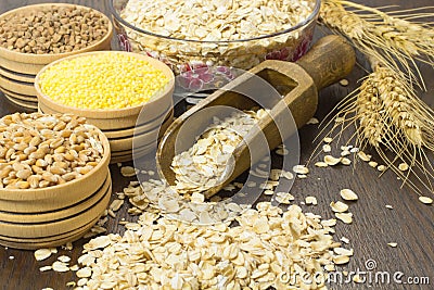 Wheat grains oats, millet, wooden spoon and a sprig of wheat on Stock Photo