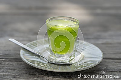 Wheat grass juice natural drink with fresh wheatgrass in glass on old wooden table background. Organic healthy organic green detox Stock Photo