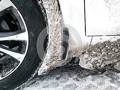 The wheel arch of the car is clogged with ice and snow Stock Photo