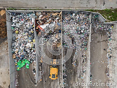 Wheel loader on the landfill site scooping and carrying waste, drone shot Stock Photo
