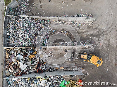 Wheel loader on the landfill site scooping and carrying waste, drone shot Stock Photo