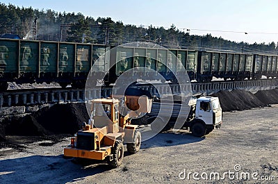 Wheel loader unloading coal into a heavy dump truck Stock Photo