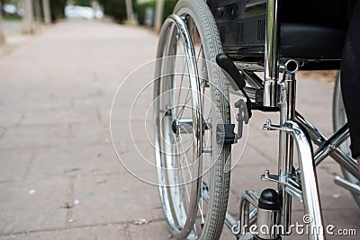 Wheelchair on the outside, in a park on a brick floor Stock Photo
