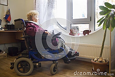 Wheelchair user looks out the window Editorial Stock Photo