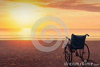 Wheelchairs parked on the beach at sunset time, in a lonely atmosphere Stock Photo