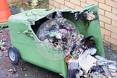 Wheelie bin vandalism on side burnt out by fire by vandals in council estate London arson attack Stock Photo