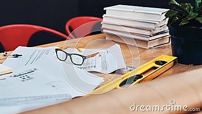 Where great designs are made. Still life shot of a pair of spectacles placed on top an architects blueprints in a modern Stock Photo