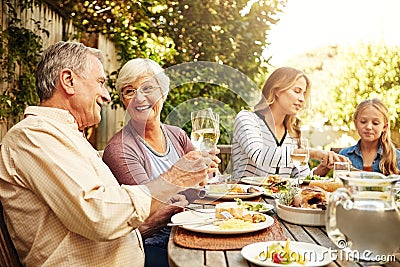 Where theres family theres food. a family eating lunch together outdoors. Stock Photo
