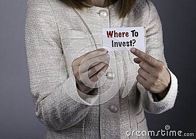 Where To Invest? Businesswoman holding a card with a message tex Stock Photo