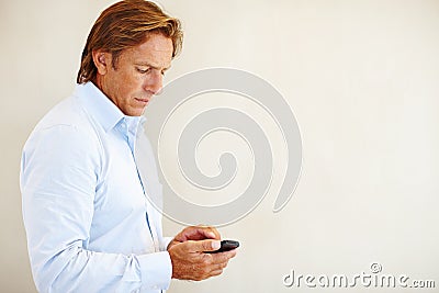 Wheres that number...a mature man sending a text from his cellphone. Stock Photo