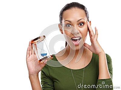 Wheres the year gone. Portrait of a shocked looking young woman holding an hourglass isolated on white. Stock Photo