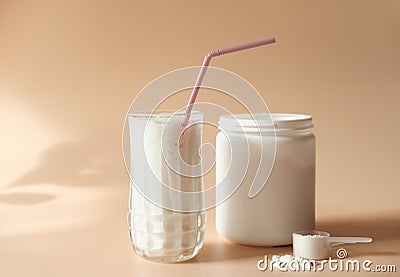 Whey drink in a high glass. whey protein vanilla cocktail. a jar with protein powder and a scoop of powder on a table. morning Stock Photo