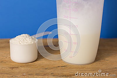 Whey Protein. Close up of scoop with vanilla powder and shaker o Stock Photo