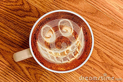 Whimsical Smiley Face Latte Art on Wood Surface Stock Photo
