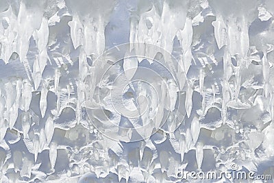 Whimsical surface ice with snow closeup on blue sky background. Stock Photo